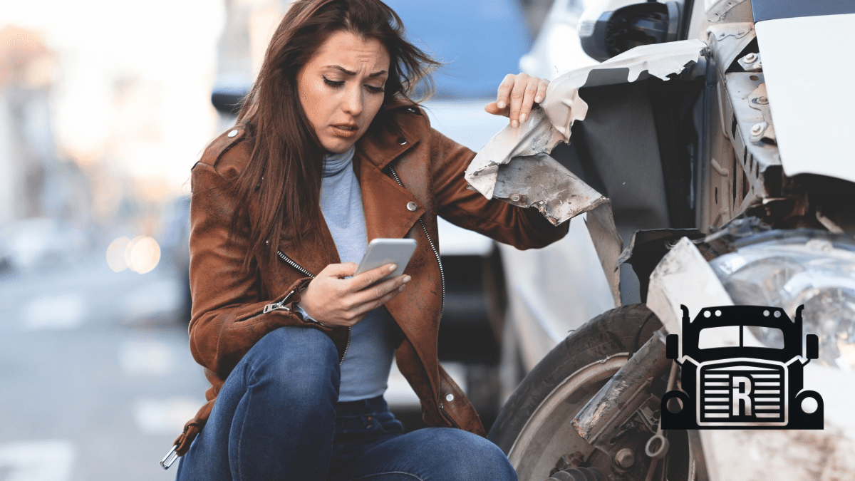 woman on her phone next to a damaged vehicle