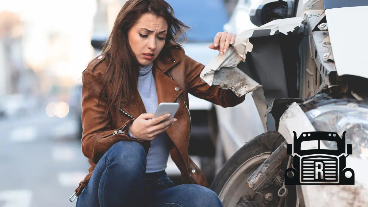 woman on her phone next to a damaged vehicle