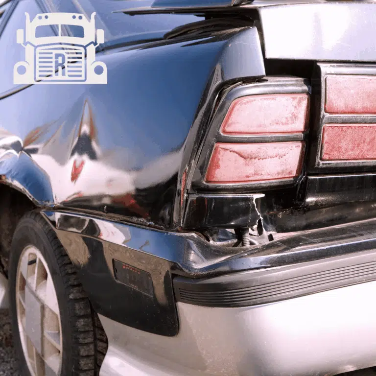 A damaged backend of a black sedan
