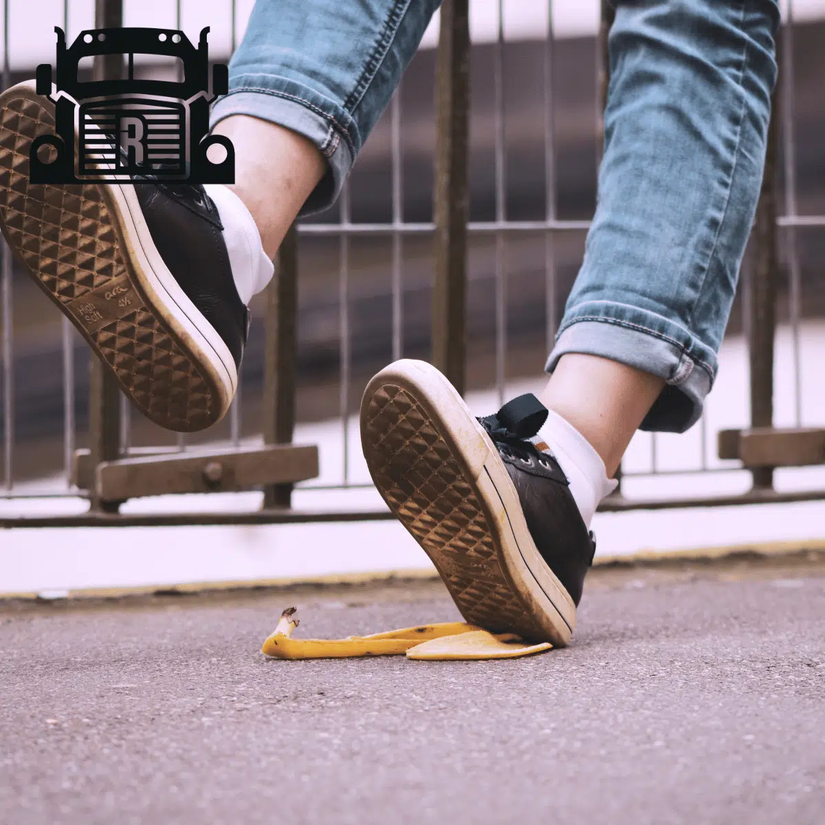 A person slipping and falling after stepping on a banana peel.
