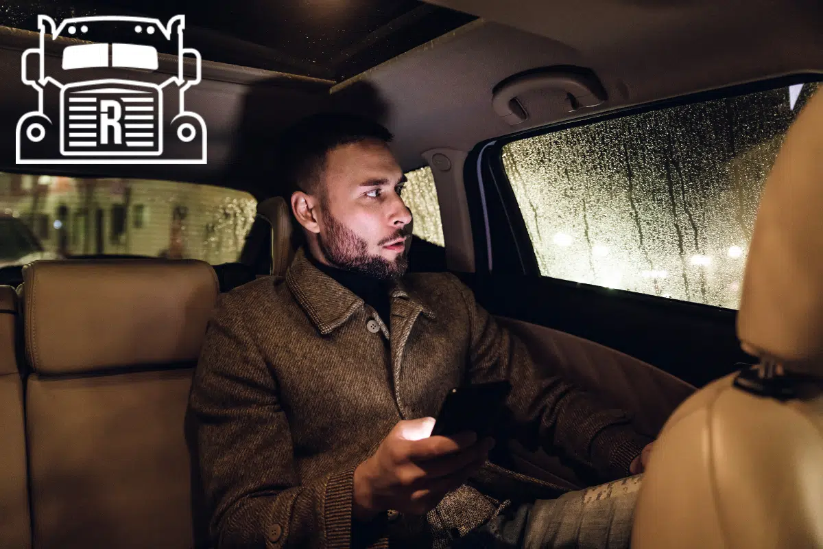 man sitting in back seat of an uber on his phone
