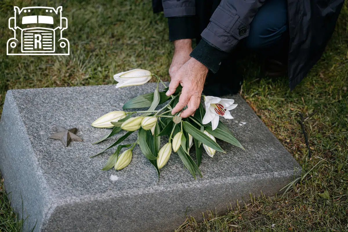 Person placing flowers on a headstone